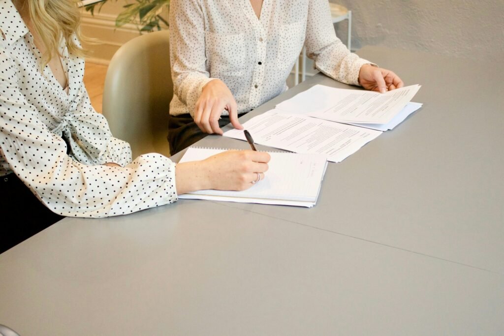 Dos personas revisando y firmando documentación de gestión